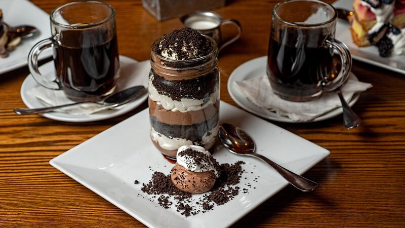 Mason jar with chocolate, vanilla cream and crushed cookies