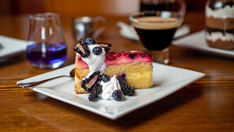 Berry cake topped with strawberries and whipped cream